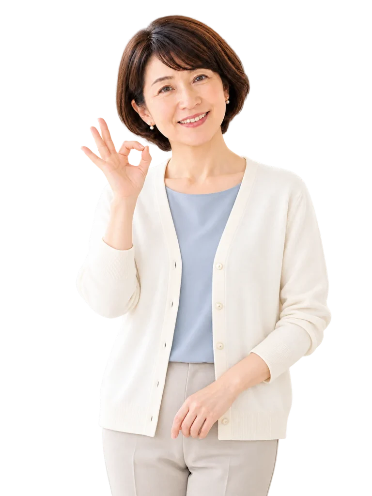 安藤広恵さんがアイボリーのカーディガン姿で、笑顔でOKサインをする様子